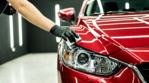 Gloved hand wiping down sports car